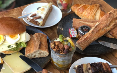 Table petit-déjeuner avec café, croissant, gâteau, fruits